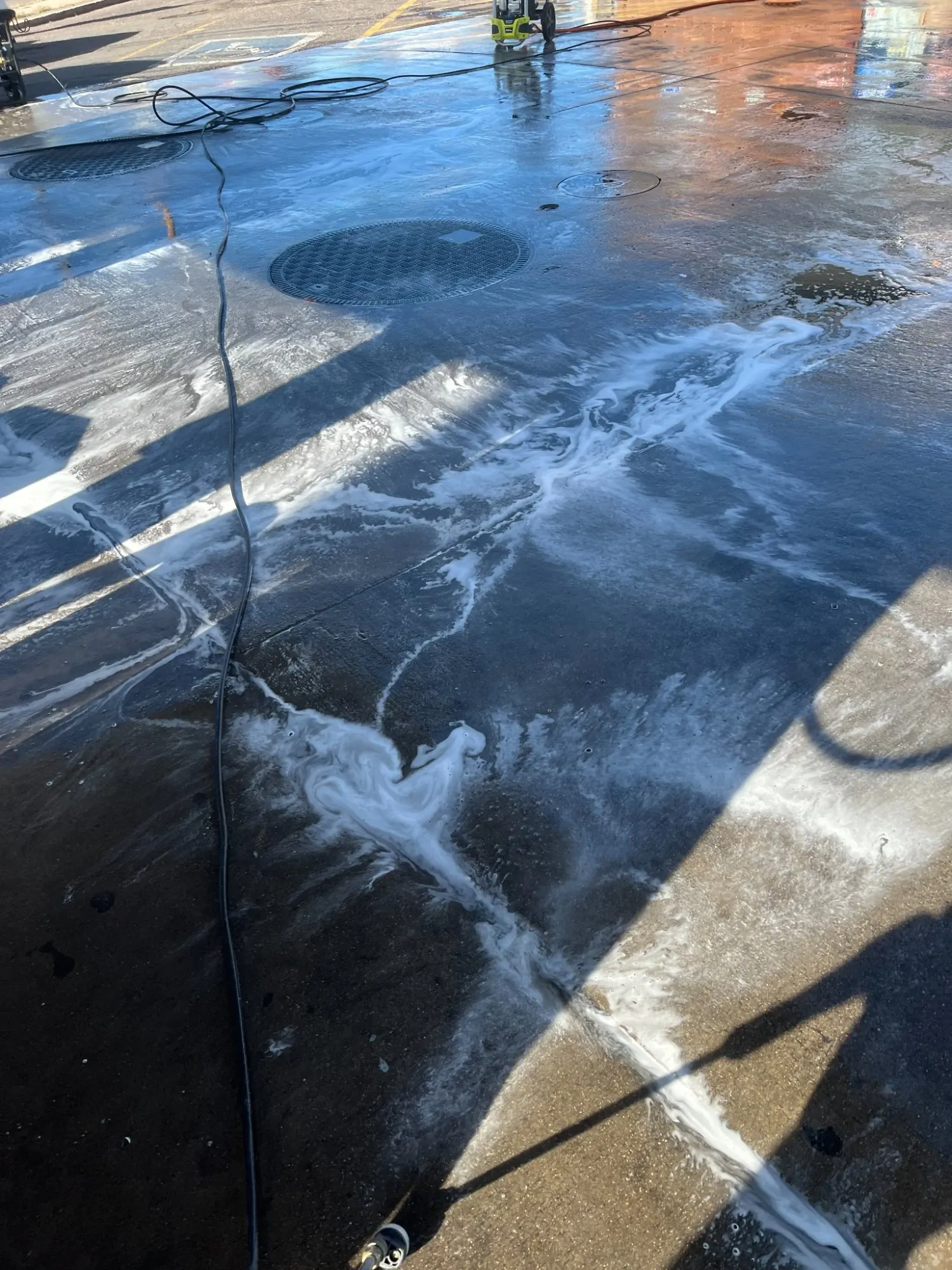 Pressure-washing equipment and freshly washed concrete during an exterior cleaning job