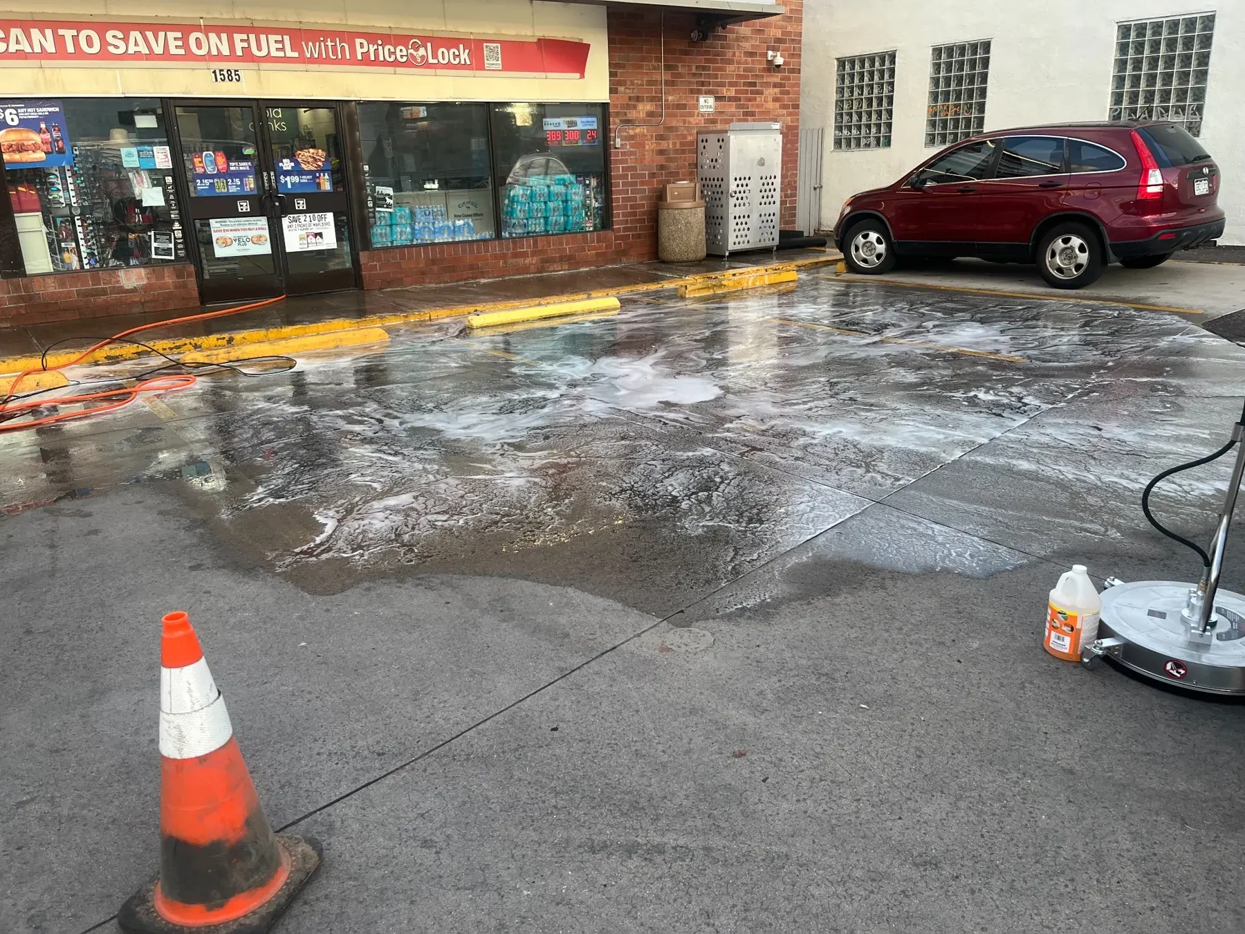 Pressure washing equipment and wet concrete outside a commercial storefront