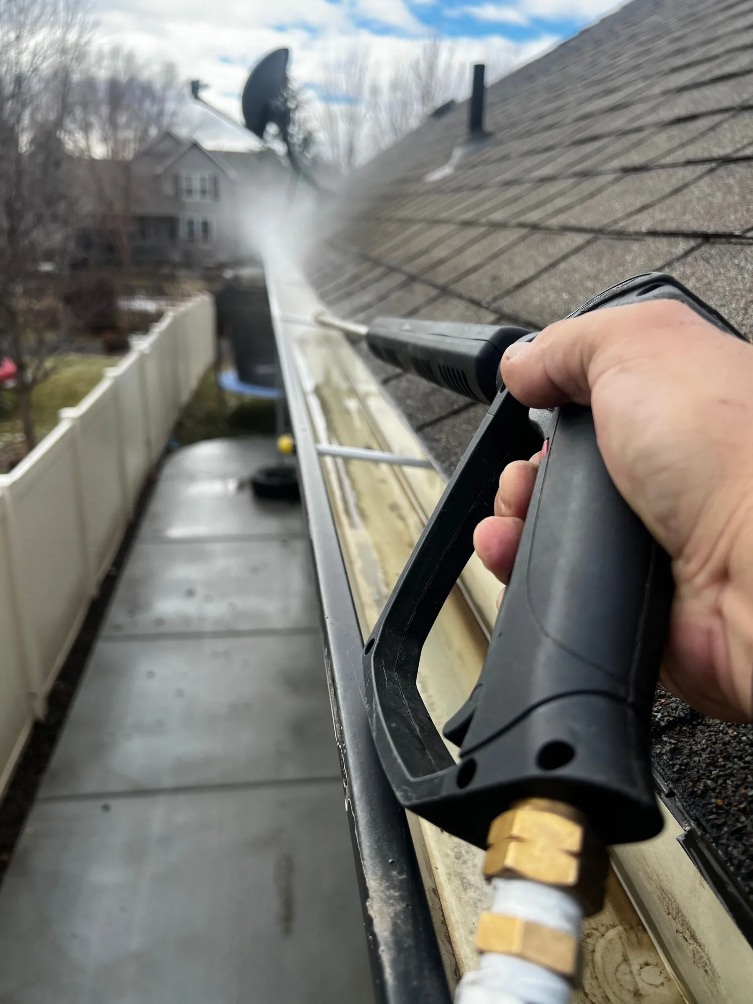 A technician cleaning an exterior gutter